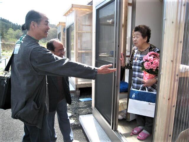江藤さんが仮設住宅に住む女性にプレゼントを渡している
