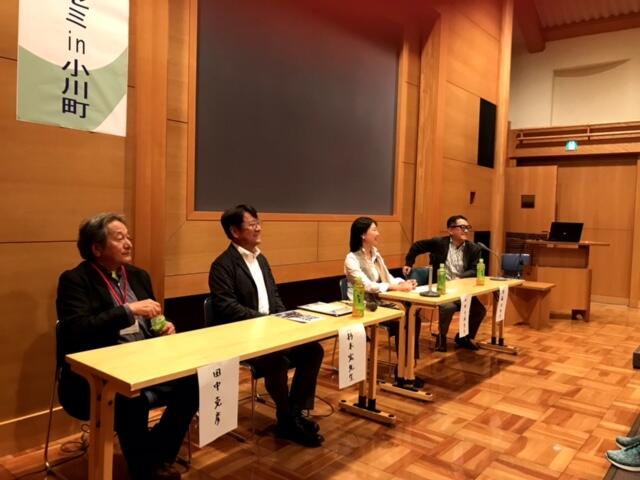 コーディネーターの後藤氏と3人の登壇者が聴衆の前で一列に並んで席に座っている。