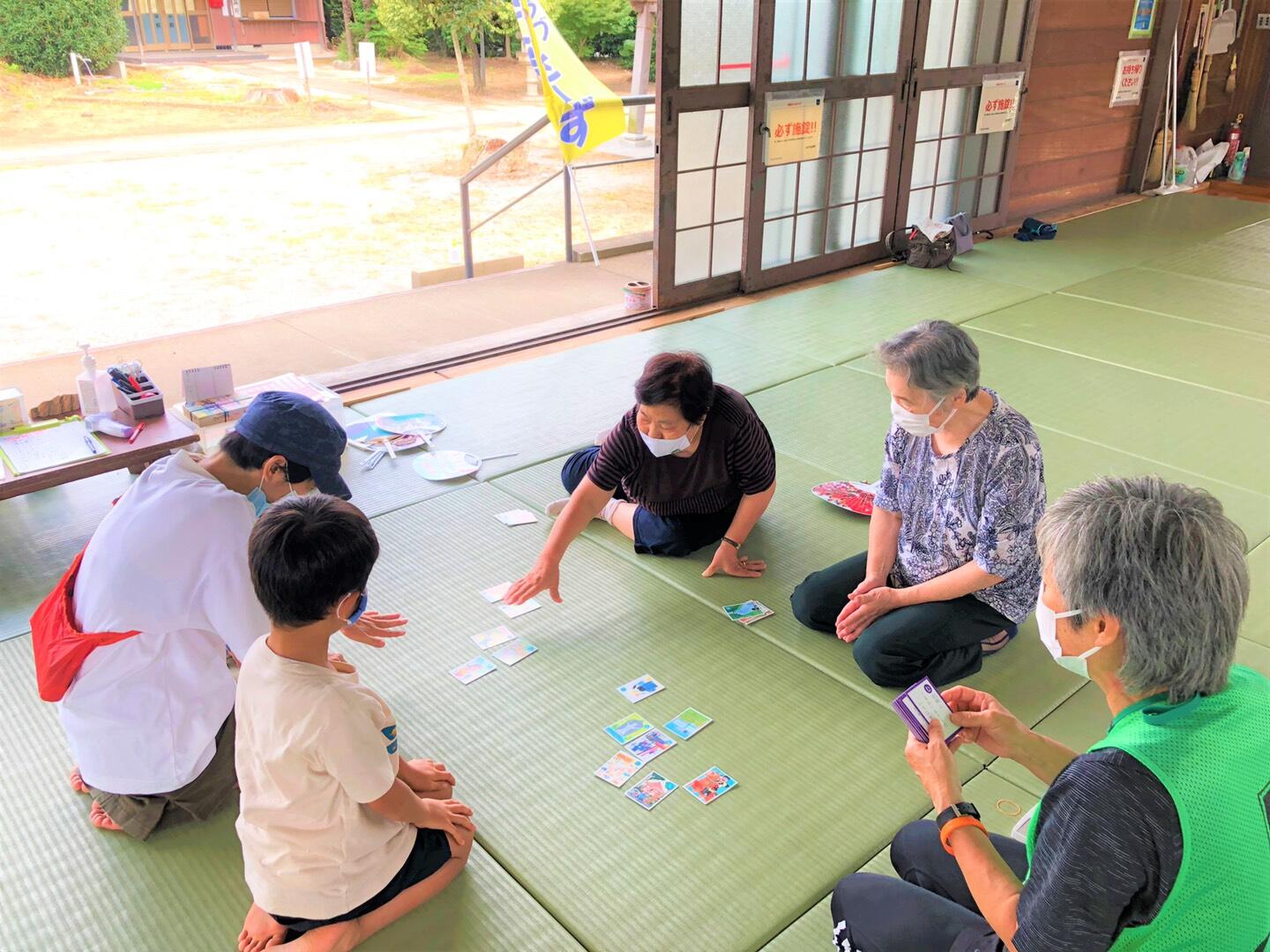 畳の上でかるた遊びをしている