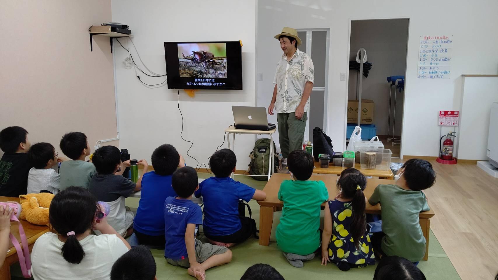 学童の前でパソコンの画面をモニターに映しながら話をする吉田さん