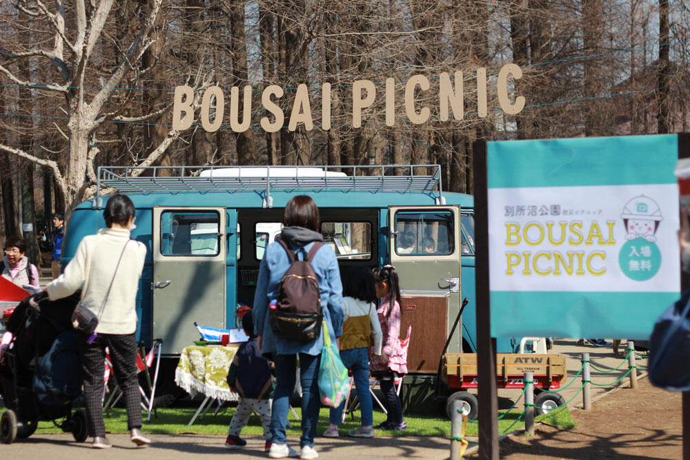 公園の敷地内で「BOUSAI PICNIC」と書かれた旗と、ブースを見つめる親子。