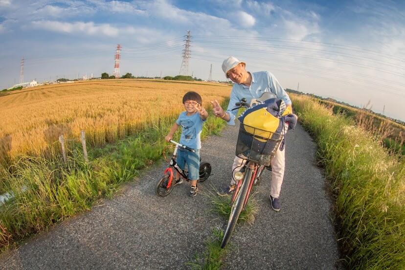 小林さんと息子さんが自転車にのってピースをしている